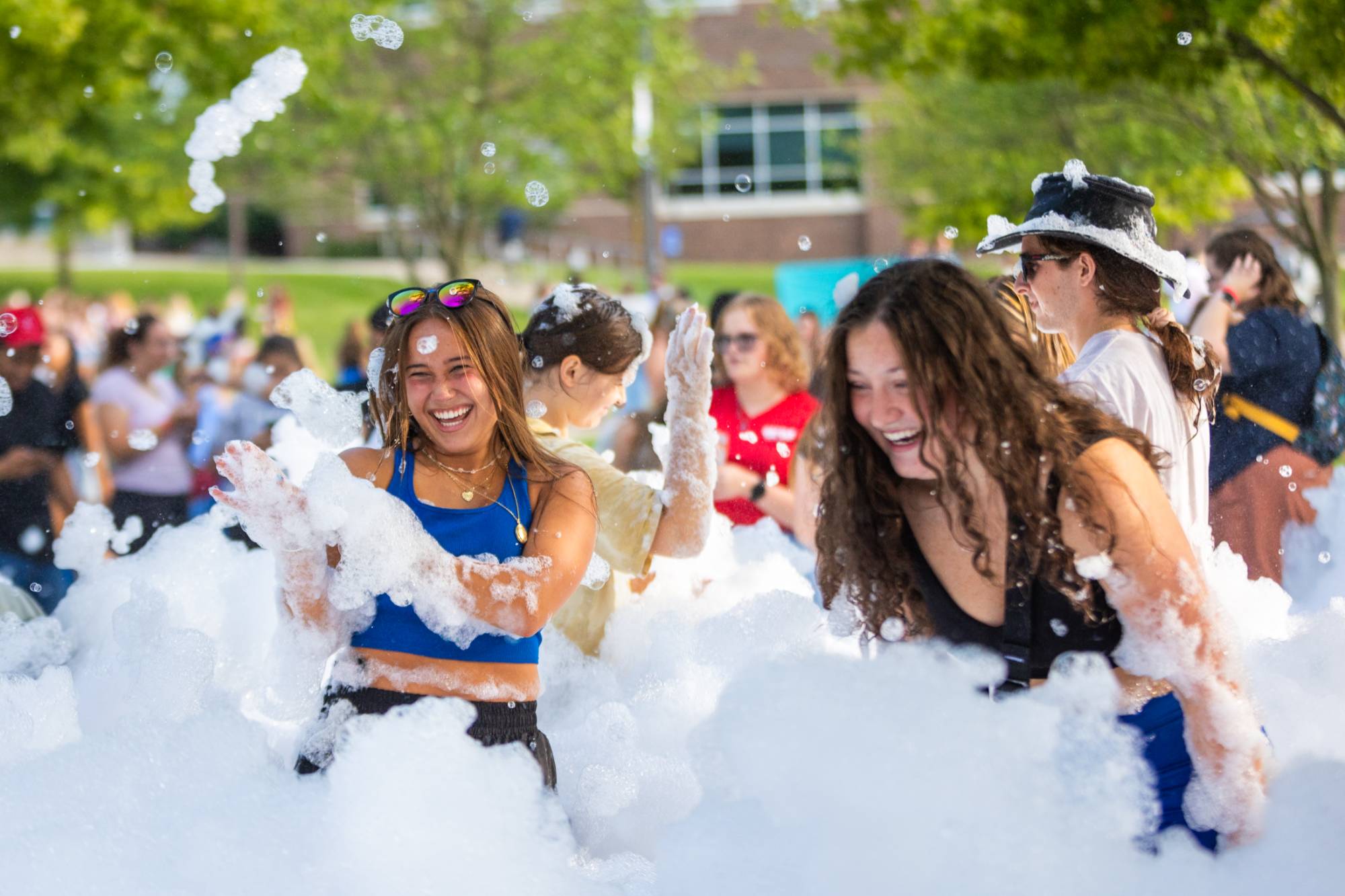 Students playing outside in a pile of sudsy bubbles